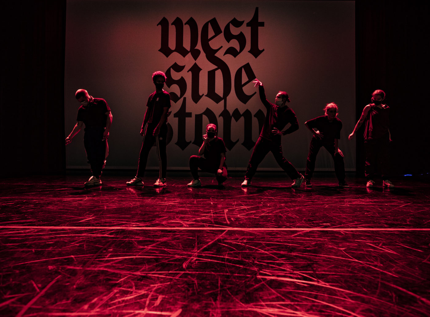 Neljä tanssijaa profiilissa, taustalla teksti West Side Story
