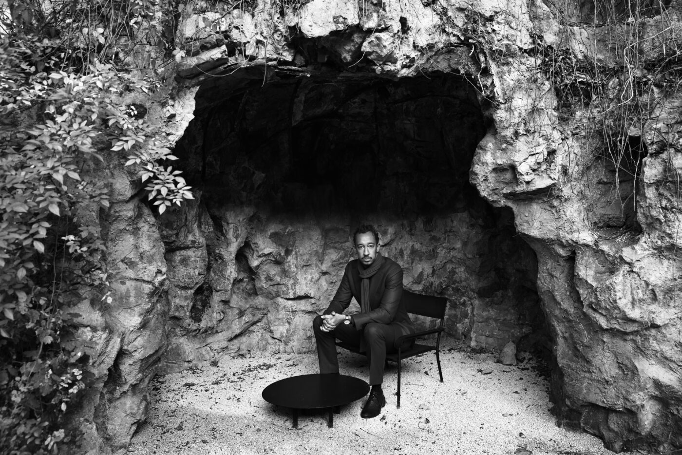 Mustavalkoinen valokuva jossa Gerald Clayton istuu tuolilla luolassa