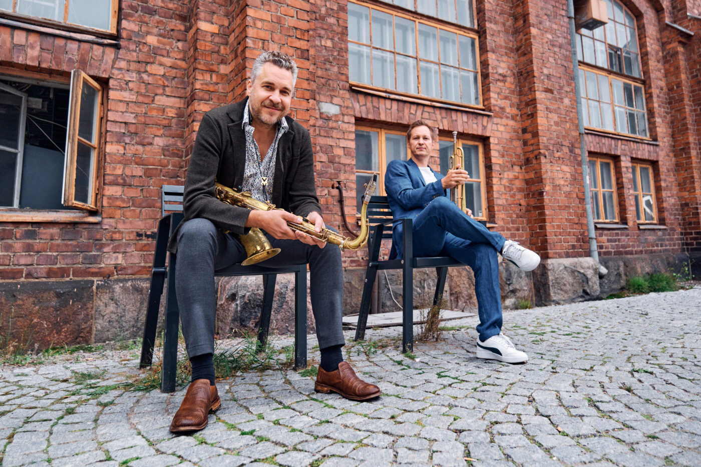 Timo Lassy ja Jukka Eskola istuvat ulkona soittimiensa kanssa